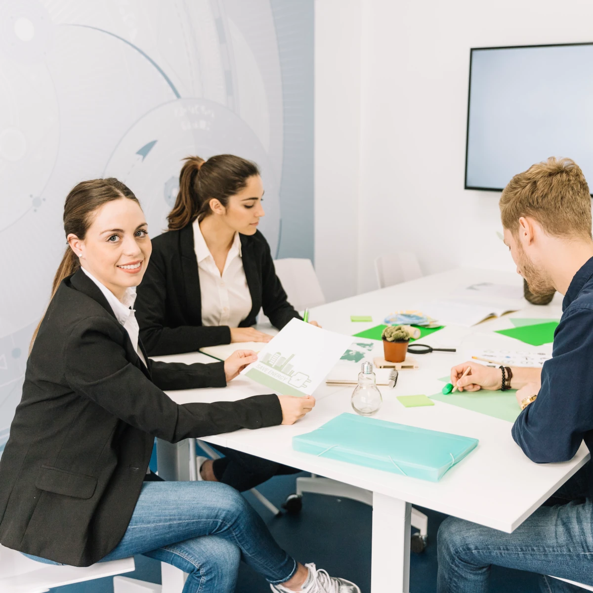 portrait of smiling young businesswoman near her colleagues working in the office